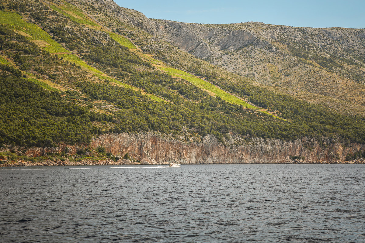 Boat passing cliff Croatia