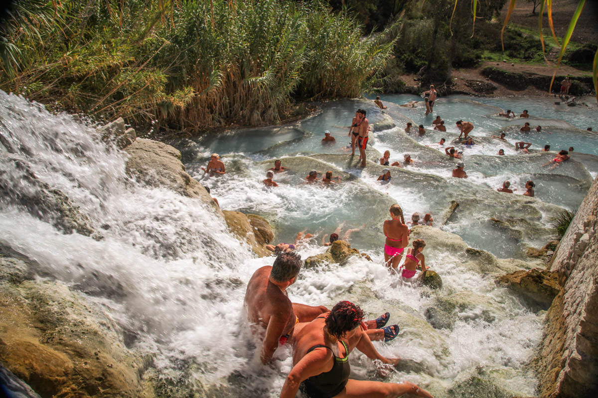 Saturnia thermal spa people under waterfall