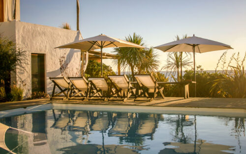 Posada del Faro pool chairs sunset